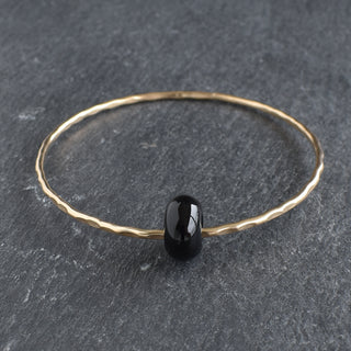 Black agate rondelle gemstone bangle featuring smooth, polished black agate beads on a sleek jewelry bracelet.