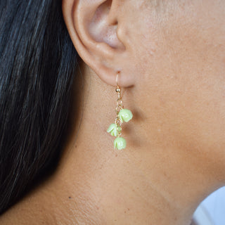 Three cascading Pakalana earrings by Yay Hawaii featuring layered floral designs with green and purple hues.