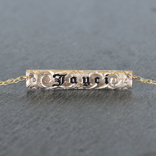 Yay Hawaii Inoa patterned bar necklace with geometric design in gold tone, close-up view of the jewelry piece.