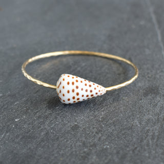 Black and white spotted cone shell bangle from Yay Hawaii, showcasing a stylish jewelry piece with natural shell design.