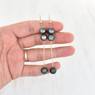 Yay Hawaii double dangle Tahitian pearl earrings featuring black pearls and silver hooks on a white background.