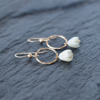 Yay Hawaii hoop earrings with dangling small mother of pearl Pikake flower design, showcasing elegant jewelry with floral accents.