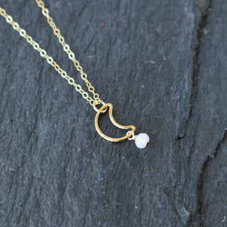 Cute crescent moon necklace with white bead from Yay Hawaii, featuring a delicate silver chain and celestial design.