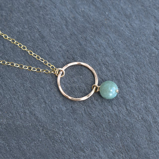 Small hoop necklace with dangling 6mm jade pendant from Yay Hawaii, featuring a delicate gold chain and vibrant green jade stone.