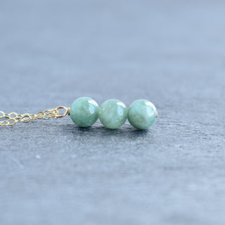 Triple 6mm jade cluster vertical pendant necklace featuring green jade stones on a silver chain.