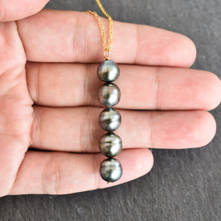Tahitian pearl vertical pendant necklace by Yay Hawaii featuring a single dark lustrous pearl on a silver chain.