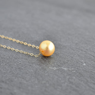 Golden freshwater floating pearl necklace featuring elegant pearls on a delicate chain, perfect for sophisticated jewelry styles.