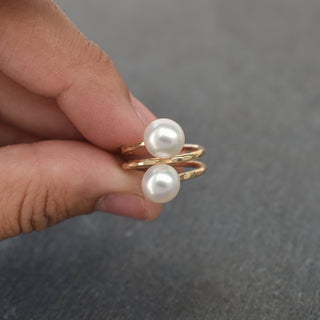White pearl double bypass ring by Yay Hawaii featuring two intertwined bands with lustrous pearls.