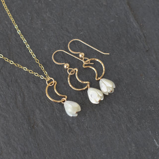 Silver crescent moon necklace featuring a small Pikake flower charm, inspired by Hawaiian jewelry design.