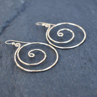 Large spiral earrings by Yay Hawaii featuring bold, silver-toned metal with a smooth, curved design on a plain background.