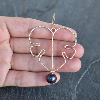 Extra large Monstera leaf earrings with black pearls in silver or gold, featuring sleek, tropical-inspired jewelry design.
