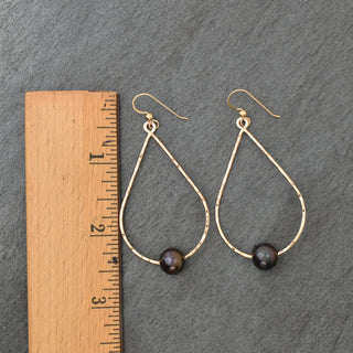 Large black pearl teardrop hoop earrings by Yay Hawaii featuring elegant, polished black pearl teardrops and gold-tone hoops.