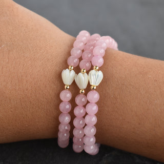 Six-millimeter rose quartz stretchy bracelet with small Pikake charm, crafted by Yay Hawaii, featuring polished pink gemstones.