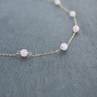 Six 6mm rose quartz beads on a Yay Hawaii station necklace, showcasing a delicate pink gemstone jewelry piece.