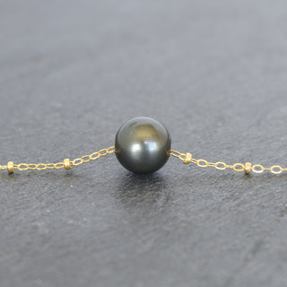 Round Tahitian pearl pendant on a delicate satellite chain necklace, showcasing a lustrous black pearl by Yay Hawaii.