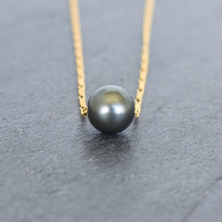 Round Tahitian pearl pendant on a Figaro chain necklace by Yay Hawaii, showcasing a lustrous black pearl and elegant silver chain.