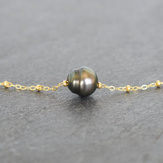 Tahitian pearl circle pendant with satellite chain necklace by Yay Hawaii, showcasing the elegant jewelry design and shiny black pearl.