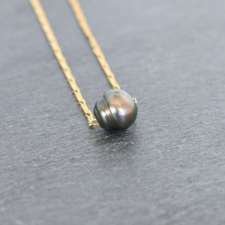 Tahitian pearl circle necklace with Figaro chain by Yay Hawaii, showcasing a lustrous black pearl on a silver chain.