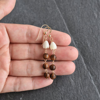 Dangling small mother of pearl Pikake earrings with triple rosewood beads, crafted by Yay Hawaii, on a white background.