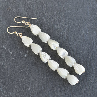 Yay Hawaii statement long medium mother of pearl Pikake earrings hanging with intricate floral design and pearl accents.