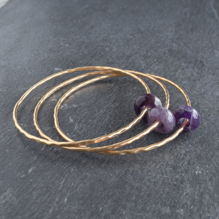 Amethyst rondelle gemstone bangle featuring polished purple beads on a silver setting, stylish jewelry accessory.