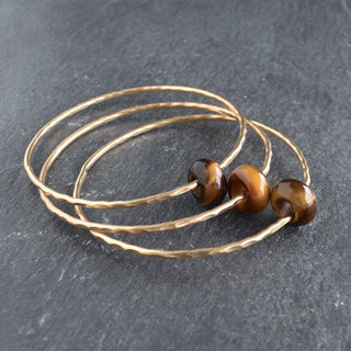 Tiger Eye rondelle gemstone bangle by Yay Hawaii featuring polished, oval-shaped tiger eye beads on a flexible bracelet.