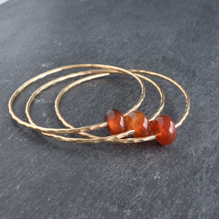 Red agate gemstone bangle featuring round rondelle beads, handmade jewelry by Yay Hawaii with vibrant red stones.