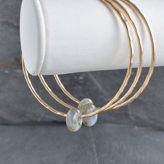 Blue flash Labradorite rondelle gemstone bangle with blue iridescent stones and silver-tone clasp, showcasing vibrant labradorite colors.