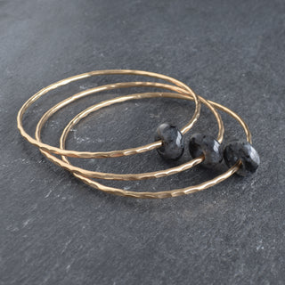 Larvikite rondelle gemstone bangle by Yay Hawaii showcasing polished dark gray and blue stones on a silver-tone bracelet.