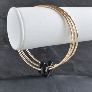 Black Agate Rondelle Gemstone Bangle featuring smooth black agate beads strung together, stylish and elegant jewelry accessory.