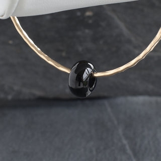 Black Agate Rondelle Gemstone Bangle showing smooth black agate beads on a flexible jewelry band.