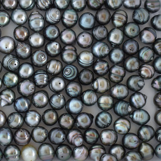 Loose Tahitian pearls from Yay Hawaii, drilled for jewelry-making, with dark, lustrous surfaces and iridescent sheen.