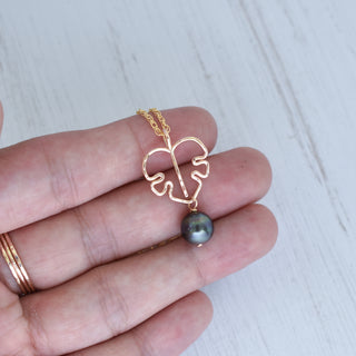 Monstera leaf pendant and black pearl necklace with silver or gold finish, stylish jewelry piece featuring nature-inspired design.