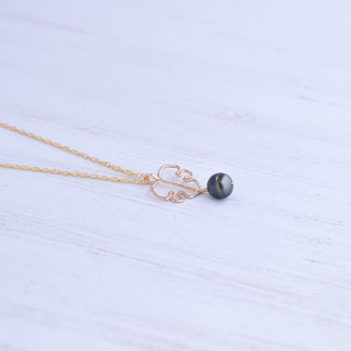 Monstera leaf pendant and black pearl necklace with silver or gold chain, showcasing tropical-inspired jewelry design.