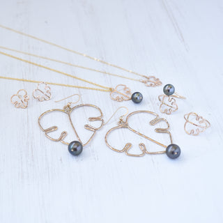 Monstera leaf pendant and black pearl necklace in silver or gold, stylish jewelry featuring a tropical leaf and pearl design.